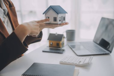 Emlak komisyoncusu, emlak kredisi teklifi ve ev sigortası için imzalı sigorta anlaşması yapma, ev modeli alma ve satma konularında müşteriye danışmanlık yapar ve sunar.