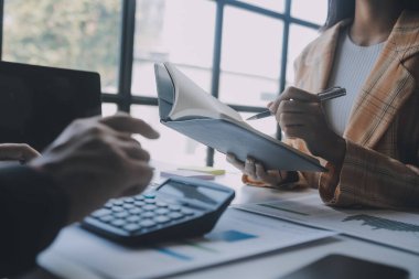 Finansal analistler, şirketlerin başarılı takım çalışmalarının sonuçlarını gösteren bir toplantıda bir dijital tablet planlama yatırım projesinin ticari mali raporlarını analiz ediyorlar..