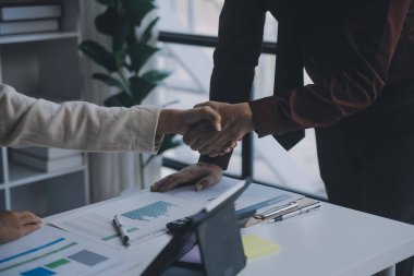 Finansal analistler, şirketlerin başarılı takım çalışmalarının sonuçlarını gösteren bir toplantıda bir dijital tablet planlama yatırım projesinin ticari mali raporlarını analiz ediyorlar..