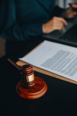 Adalet ve hukuk kavramı. Bir mahkeme salonunda tokmakla çalışan, bilgisayar ve kenetlenme klavyesi, gözlük takan bir erkek yargıç, sabah ışığında masada.