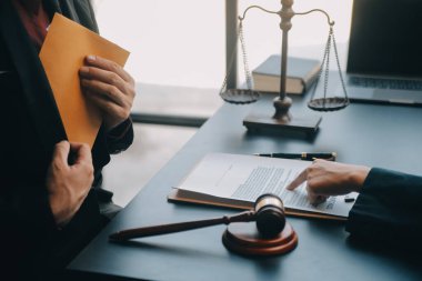 Adalet ve hukuk kavramı. Bir mahkeme salonunda tokmakla çalışan, bilgisayar ve kenetlenme klavyesi, gözlük takan bir erkek yargıç, sabah ışığında masada.