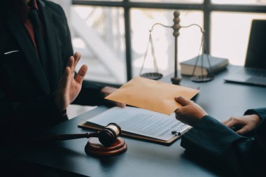 Adalet ve hukuk kavramı. Bir mahkeme salonunda tokmakla çalışan, bilgisayar ve kenetlenme klavyesi, gözlük takan bir erkek yargıç, sabah ışığında masada.