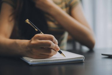 Asyalı iş kadını dizüstü bilgisayar kullanıyor ve ofiste hesap makinesi ile çalışıyor, mali raporu, iş planı yatırımını, mali analiz konseptini analiz etmeyi planlıyor..