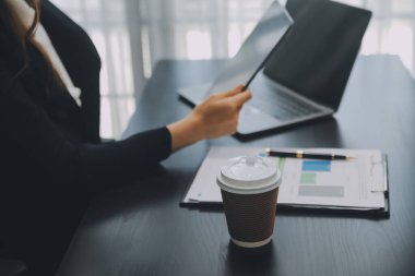 Asyalı iş kadını dizüstü bilgisayar kullanıyor ve ofiste hesap makinesi ile çalışıyor, mali raporu, iş planı yatırımını, mali analiz konseptini analiz etmeyi planlıyor..