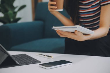 Asyalı iş kadını dizüstü bilgisayar kullanıyor ve ofiste hesap makinesi ile çalışıyor, mali raporu, iş planı yatırımını, mali analiz konseptini analiz etmeyi planlıyor..