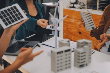 Elektrik mühendisi ve iş adamı binanın çatısındaki yeni güneş pili panelini tartışıyorlar. Alternatif enerji kavramı.