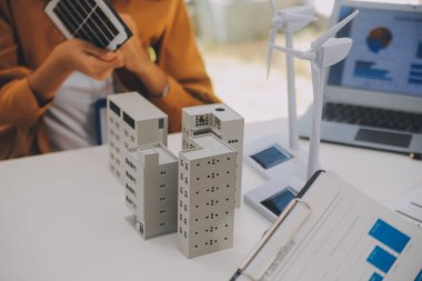 Elektrik mühendisi ve iş adamı binanın çatısındaki yeni güneş pili panelini tartışıyorlar. Alternatif enerji kavramı.