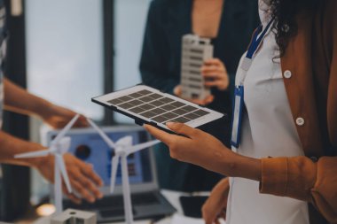 Elektrik mühendisi ve iş adamı binanın çatısındaki yeni güneş pili panelini tartışıyorlar. Alternatif enerji kavramı.