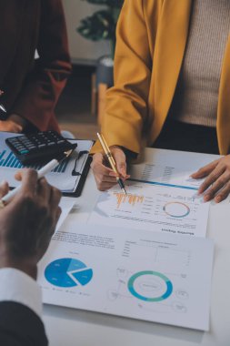 Finansal analistler, şirketlerin başarılı takım çalışmalarının sonuçlarını gösteren bir toplantıda bir dijital tablet planlama yatırım projesinin ticari mali raporlarını analiz ediyorlar..