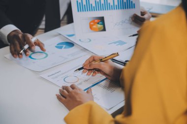 Finansal analistler, şirketlerin başarılı takım çalışmalarının sonuçlarını gösteren bir toplantıda bir dijital tablet planlama yatırım projesinin ticari mali raporlarını analiz ediyorlar..