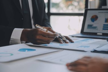 Finansal analistler, şirketlerin başarılı takım çalışmalarının sonuçlarını gösteren bir toplantıda bir dijital tablet planlama yatırım projesinin ticari mali raporlarını analiz ediyorlar..