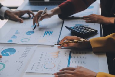 Finansal analistler, şirketlerin başarılı takım çalışmalarının sonuçlarını gösteren bir toplantıda bir dijital tablet planlama yatırım projesinin ticari mali raporlarını analiz ediyorlar..