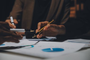 Finansal analistler, şirketlerin başarılı takım çalışmalarının sonuçlarını gösteren bir toplantıda bir dijital tablet planlama yatırım projesinin ticari mali raporlarını analiz ediyorlar..