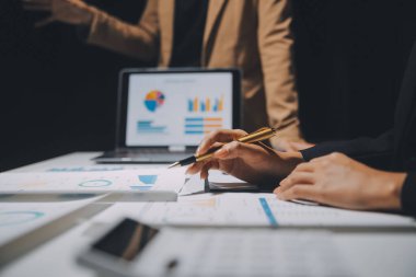 Finansal analistler, şirketlerin başarılı takım çalışmalarının sonuçlarını gösteren bir toplantıda bir dijital tablet planlama yatırım projesinin ticari mali raporlarını analiz ediyorlar..