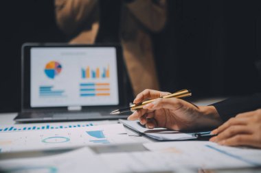 Finansal analistler, şirketlerin başarılı takım çalışmalarının sonuçlarını gösteren bir toplantıda bir dijital tablet planlama yatırım projesinin ticari mali raporlarını analiz ediyorlar..