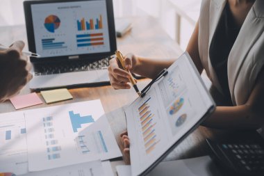 Modern dizüstü bilgisayarla gelir tabloları ve grafiklerini analiz eden iş ekibini kapatın. İş analizi ve strateji kavramı.