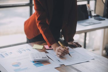 Modern dizüstü bilgisayarla gelir tabloları ve grafiklerini analiz eden iş ekibini kapatın. İş analizi ve strateji kavramı.