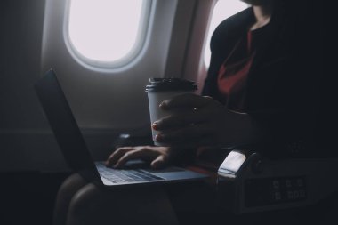 Sarışın kadın turist gelen bildirim netbook ile uçak koltuğunda oturan Smartphone cep telefonu ile kontrol. Genç işkadını paylaşmak medya telefonu dizüstü bilgisayar üzerinde uçak uçuş sırasında