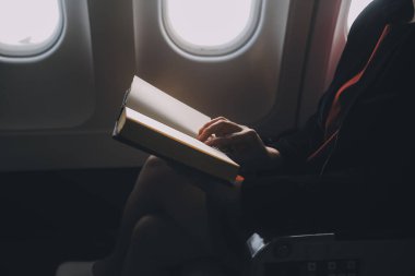 Sarışın kadın turist gelen bildirim netbook ile uçak koltuğunda oturan Smartphone cep telefonu ile kontrol. Genç işkadını paylaşmak medya telefonu dizüstü bilgisayar üzerinde uçak uçuş sırasında