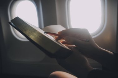 Sarışın kadın turist gelen bildirim netbook ile uçak koltuğunda oturan Smartphone cep telefonu ile kontrol. Genç işkadını paylaşmak medya telefonu dizüstü bilgisayar üzerinde uçak uçuş sırasında
