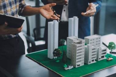 Emlak komisyoncusu müşteriye bir model ev örneği, ipotek sözleşmesi ev kiralama ve satın alma ve satma ve ipotek kredisi konsepti verir.