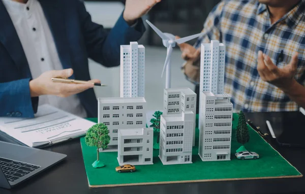 Emlak komisyoncusu müşteriye bir model ev örneği, ipotek sözleşmesi ev kiralama ve satın alma ve satma ve ipotek kredisi konsepti verir.