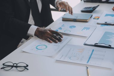 Finansal analistler, şirketlerin başarılı takım çalışmalarının sonuçlarını gösteren bir toplantıda bir dijital tablet planlama yatırım projesinin ticari mali raporlarını analiz ediyorlar..