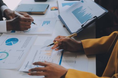 Finansal analistler, şirketlerin başarılı takım çalışmalarının sonuçlarını gösteren bir toplantıda bir dijital tablet planlama yatırım projesinin ticari mali raporlarını analiz ediyorlar..