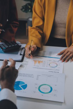 Finansal analistler, şirketlerin başarılı takım çalışmalarının sonuçlarını gösteren bir toplantıda bir dijital tablet planlama yatırım projesinin ticari mali raporlarını analiz ediyorlar..