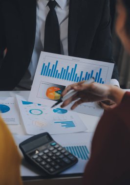 Finansal analistler, şirketlerin başarılı takım çalışmalarının sonuçlarını gösteren bir toplantıda bir dijital tablet planlama yatırım projesinin ticari mali raporlarını analiz ediyorlar..