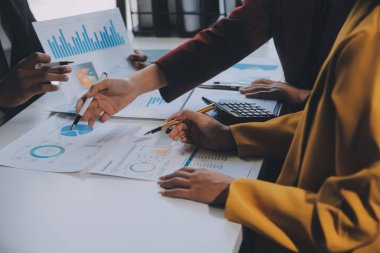 Finansal analistler, şirketlerin başarılı takım çalışmalarının sonuçlarını gösteren bir toplantıda bir dijital tablet planlama yatırım projesinin ticari mali raporlarını analiz ediyorlar..