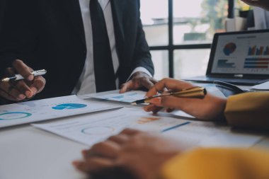 Finansal analistler, şirketlerin başarılı takım çalışmalarının sonuçlarını gösteren bir toplantıda bir dijital tablet planlama yatırım projesinin ticari mali raporlarını analiz ediyorlar..