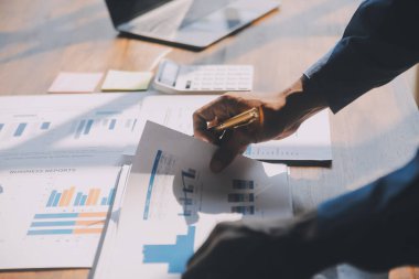 Modern dizüstü bilgisayarla gelir tabloları ve grafiklerini analiz eden iş ekibini kapatın. İş analizi ve strateji kavramı.