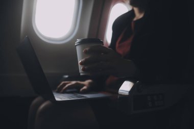 Sarışın kadın turist gelen bildirim netbook ile uçak koltuğunda oturan Smartphone cep telefonu ile kontrol. Genç işkadını paylaşmak medya telefonu dizüstü bilgisayar üzerinde uçak uçuş sırasında