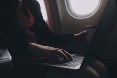 Sarışın kadın turist gelen bildirim netbook ile uçak koltuğunda oturan Smartphone cep telefonu ile kontrol. Genç işkadını paylaşmak medya telefonu dizüstü bilgisayar üzerinde uçak uçuş sırasında