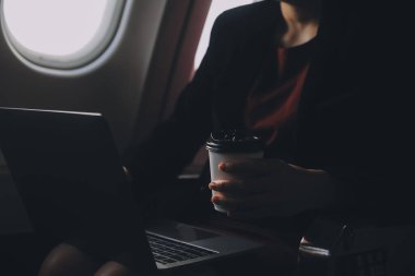 Sarışın kadın turist gelen bildirim netbook ile uçak koltuğunda oturan Smartphone cep telefonu ile kontrol. Genç işkadını paylaşmak medya telefonu dizüstü bilgisayar üzerinde uçak uçuş sırasında