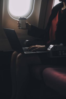 Sarışın kadın turist gelen bildirim netbook ile uçak koltuğunda oturan Smartphone cep telefonu ile kontrol. Genç işkadını paylaşmak medya telefonu dizüstü bilgisayar üzerinde uçak uçuş sırasında