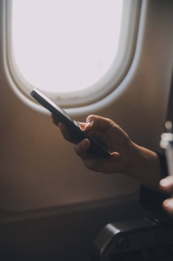 Sarışın kadın turist gelen bildirim netbook ile uçak koltuğunda oturan Smartphone cep telefonu ile kontrol. Genç işkadını paylaşmak medya telefonu dizüstü bilgisayar üzerinde uçak uçuş sırasında