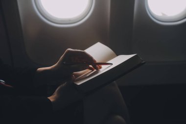 Sarışın kadın turist gelen bildirim netbook ile uçak koltuğunda oturan Smartphone cep telefonu ile kontrol. Genç işkadını paylaşmak medya telefonu dizüstü bilgisayar üzerinde uçak uçuş sırasında