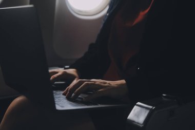 Sarışın kadın turist gelen bildirim netbook ile uçak koltuğunda oturan Smartphone cep telefonu ile kontrol. Genç işkadını paylaşmak medya telefonu dizüstü bilgisayar üzerinde uçak uçuş sırasında