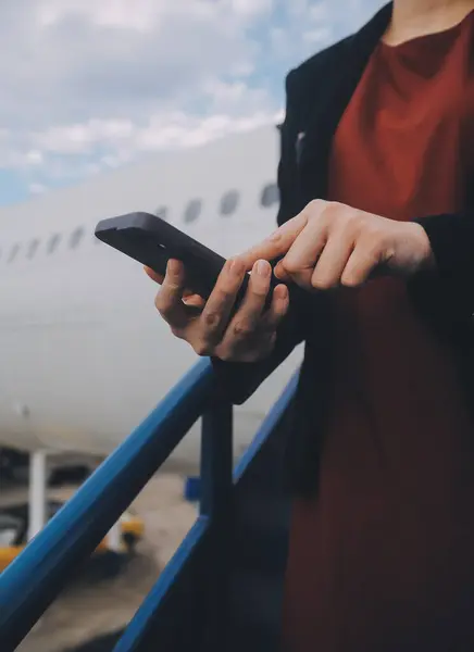 stock image Young asian woman in international airport, using mobile smartphone and checking flight at the flight information board