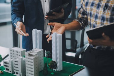 Emlak komisyoncusu müşteriye bir model ev örneği, ipotek sözleşmesi ev kiralama ve satın alma ve satma ve ipotek kredisi konsepti verir.