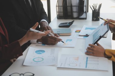 Finansal analistler, şirketlerin başarılı takım çalışmalarının sonuçlarını gösteren bir toplantıda bir dijital tablet planlama yatırım projesinin ticari mali raporlarını analiz ediyorlar..