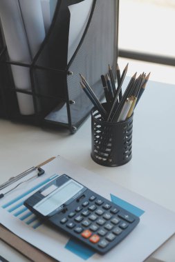 Finansal analistler, şirketlerin başarılı takım çalışmalarının sonuçlarını gösteren bir toplantıda bir dijital tablet planlama yatırım projesinin ticari mali raporlarını analiz ediyorlar..