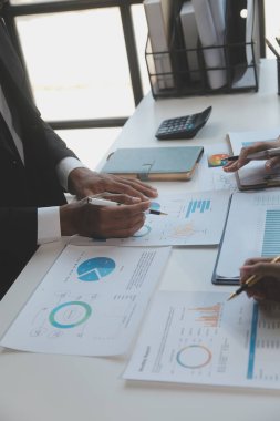 Finansal analistler, şirketlerin başarılı takım çalışmalarının sonuçlarını gösteren bir toplantıda bir dijital tablet planlama yatırım projesinin ticari mali raporlarını analiz ediyorlar..