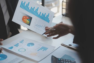 Finansal analistler, şirketlerin başarılı takım çalışmalarının sonuçlarını gösteren bir toplantıda bir dijital tablet planlama yatırım projesinin ticari mali raporlarını analiz ediyorlar..