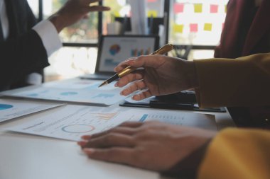 Finansal analistler, şirketlerin başarılı takım çalışmalarının sonuçlarını gösteren bir toplantıda bir dijital tablet planlama yatırım projesinin ticari mali raporlarını analiz ediyorlar..