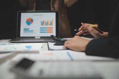 Finansal analistler, şirketlerin başarılı takım çalışmalarının sonuçlarını gösteren bir toplantıda bir dijital tablet planlama yatırım projesinin ticari mali raporlarını analiz ediyorlar..
