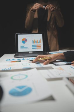 Finansal analistler, şirketlerin başarılı takım çalışmalarının sonuçlarını gösteren bir toplantıda bir dijital tablet planlama yatırım projesinin ticari mali raporlarını analiz ediyorlar..