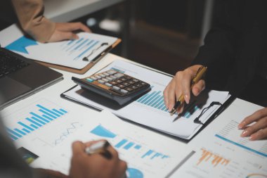 Finansal analistler, şirketlerin başarılı takım çalışmalarının sonuçlarını gösteren bir toplantıda bir dijital tablet planlama yatırım projesinin ticari mali raporlarını analiz ediyorlar..